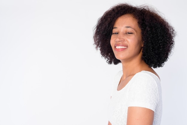 Vue de profil gros plan de l'heureuse jeune belle femme africaine regardant la caméra