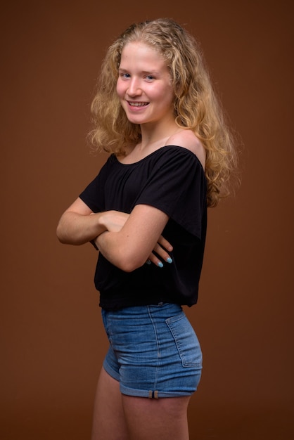 Vue de profil portrait de jeune belle adolescente blonde souriante