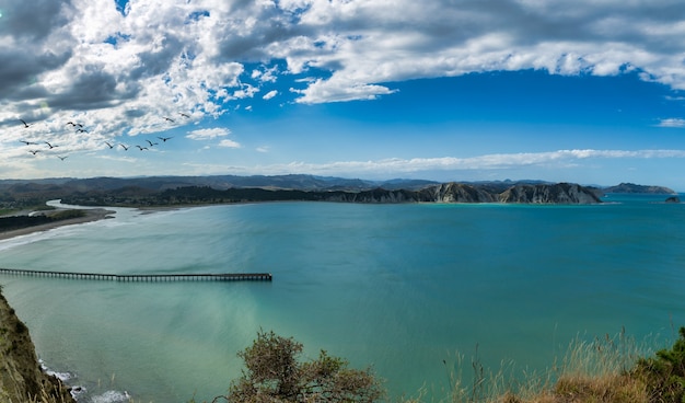 Vue sur le quai de la baie de Tolaga depuis les collines côtières voisines