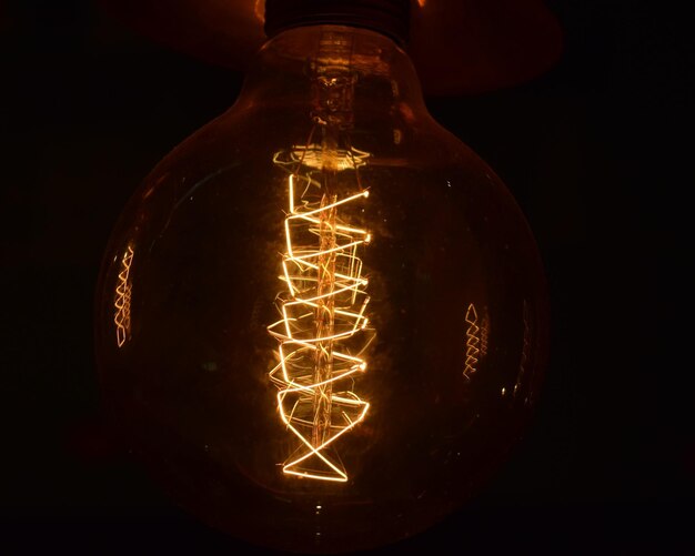 Photo vue rapprochée d'une ampoule éclairée dans une chambre noire