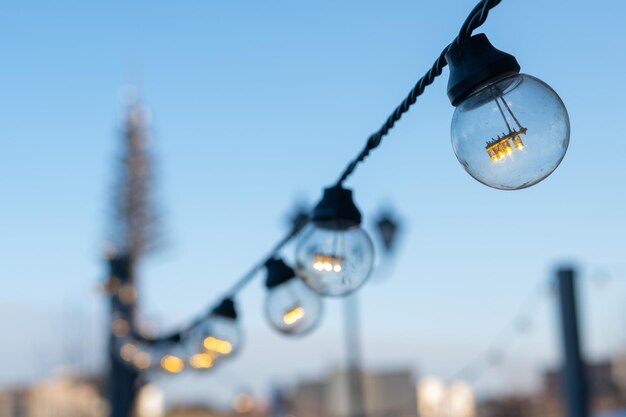 Photo vue rapprochée d'une ampoule éclairée suspendue à l'extérieur