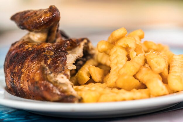 Photo vue rapprochée d'une assiette avec poulet rôti et frites