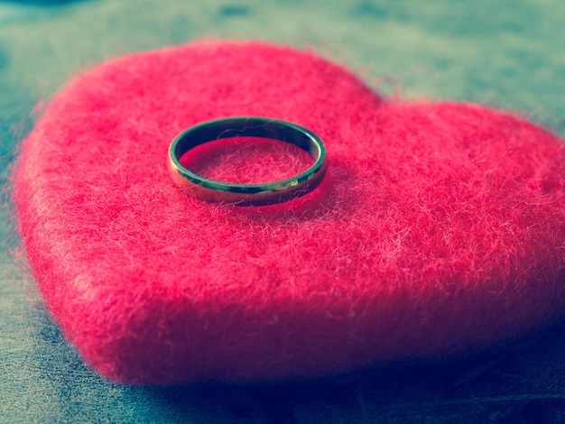 Photo vue rapprochée d'une bague de mariage en forme de cœur sur la table