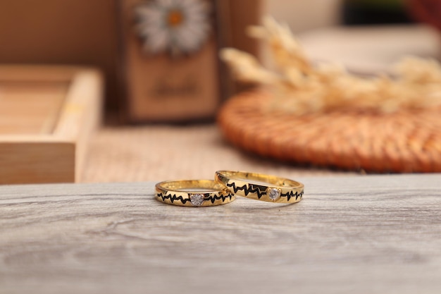 Photo vue rapprochée de la bague de mariage en or et belle sur table en bois