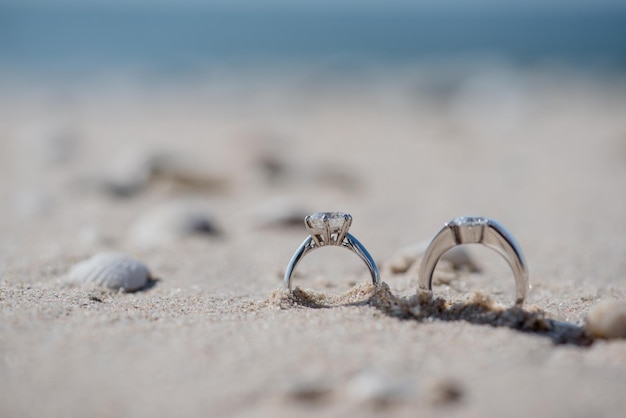 Photo vue rapprochée des bagues de mariage sur le sable