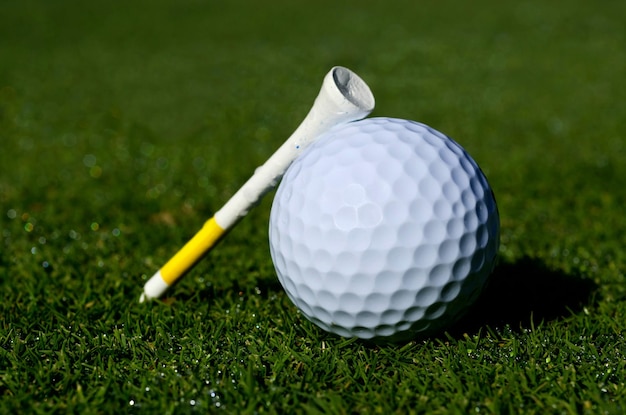 Vue rapprochée d'une balle de golf et d'un tee sur l'herbe