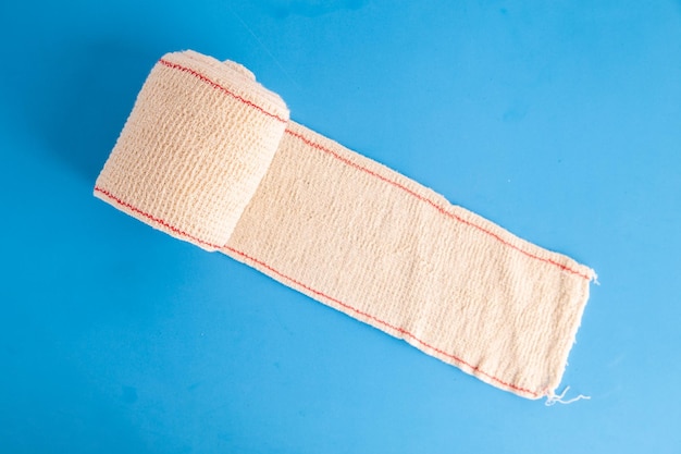 Vue rapprochée d'un bandage roulé sur un fond coloré