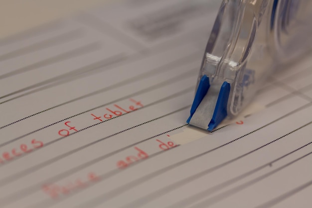 Vue rapprochée d'une bande correctrice pour supprimer le texte écrit sur une feuille de papier