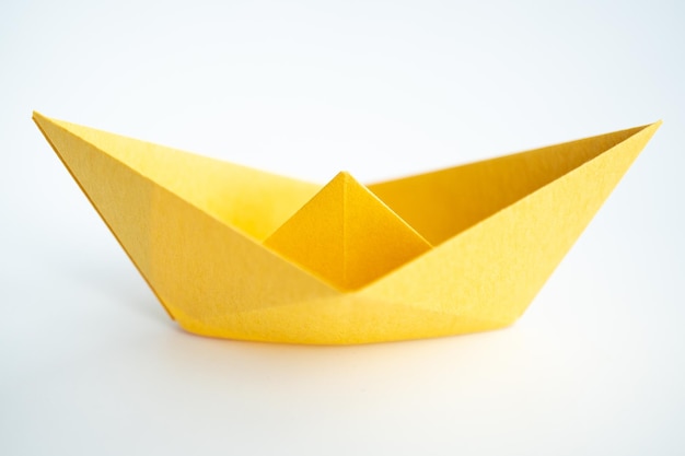 Vue rapprochée d'un bateau en papier jaune sur fond blanc