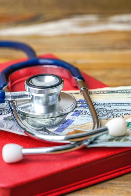 Photo vue rapprochée de billets de papier avec stéthoscope sur une table en bois