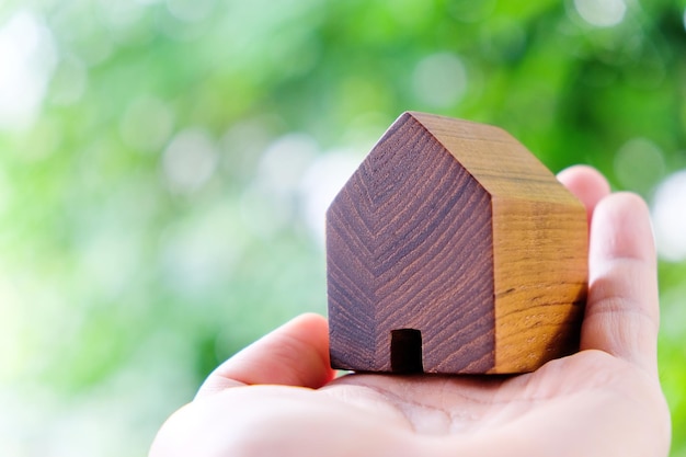 Vue rapprochée d'un bois en forme de maison tenu à la main