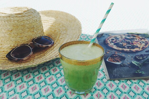 Vue rapprochée d'une boisson avec un chapeau et des lunettes de soleil sur la table