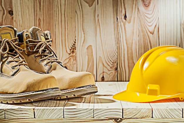 Vue rapprochée des bottes et du casque sur fond de bois