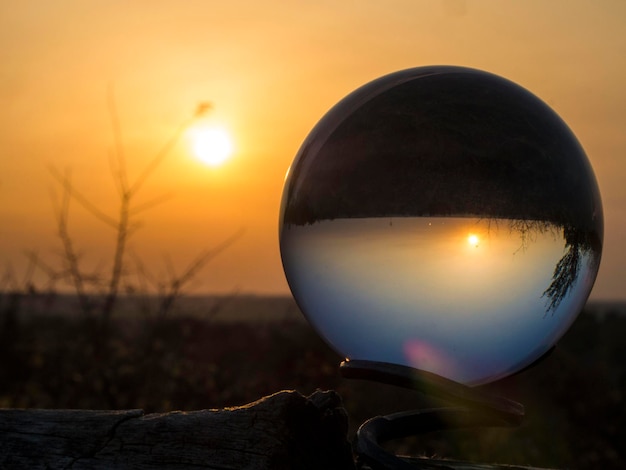 Vue rapprochée d'une boule de cristal illuminée contre le ciel au coucher du soleil