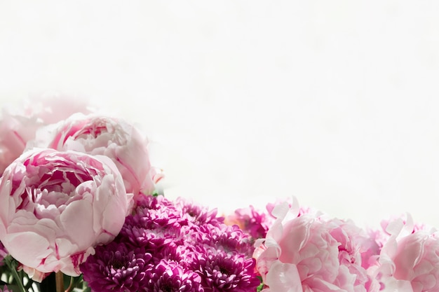 Vue rapprochée d'un bouquet de pivoines roses et de chrysanthèmes sur fond blanc. Fond de concept, fleurs, vacances.