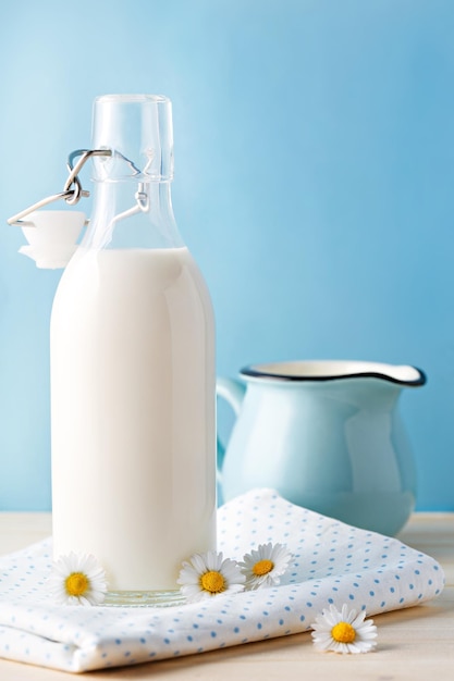 Vue rapprochée d'une bouteille de lait avec des fleurs sur une nappe
