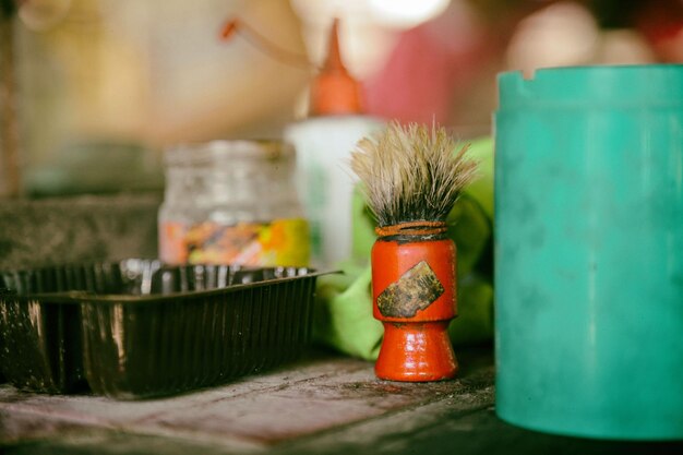 Vue rapprochée d'une brosse à raser par des récipients sur la table