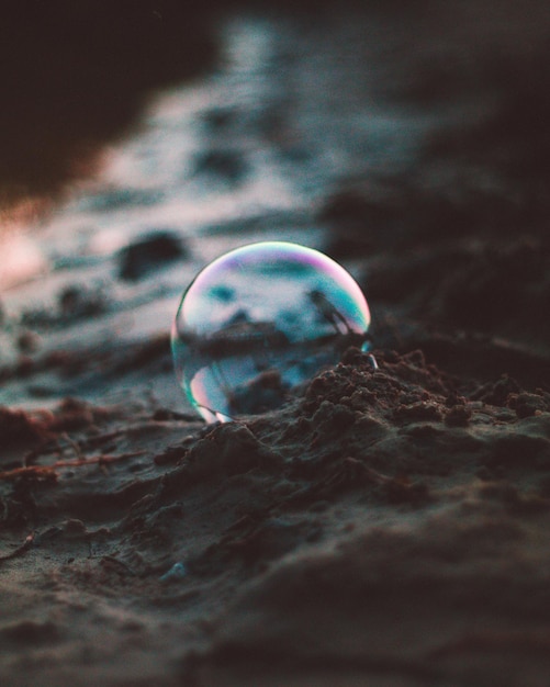 Photo vue rapprochée d'une bulle sur le sable de la plage au coucher du soleil
