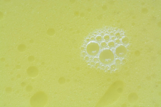 Une vue rapprochée des bulles sur le liquide de lavage jaune créant un fond bouillonnant