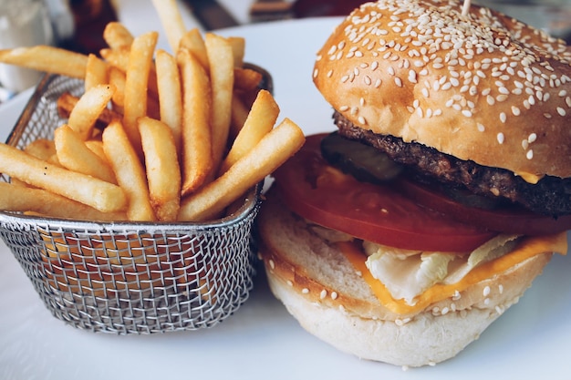 Vue rapprochée d'un burger et de frites servies dans une assiette