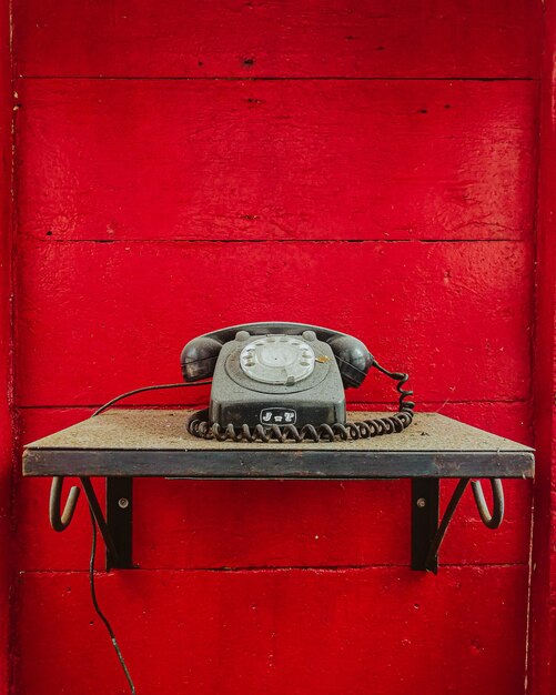 Vue rapprochée d'une cabine téléphonique sur le mur rouge