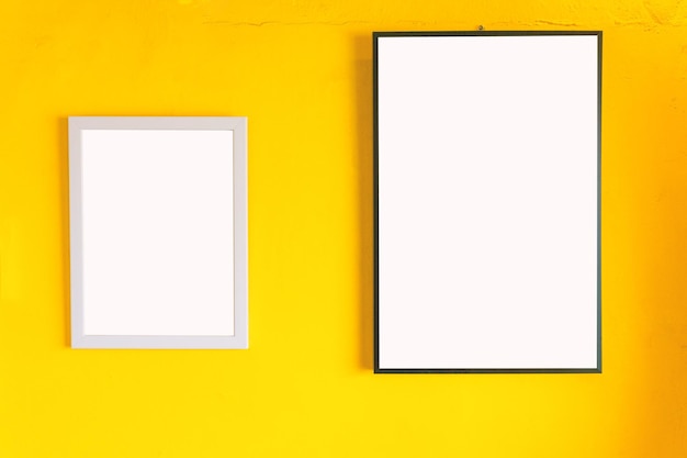 Vue rapprochée des cadres blancs sur le mur jaune