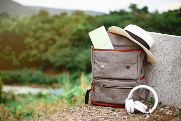 Photo vue rapprochée de la carte dans un sac à dos avec un chapeau et des écouteurs