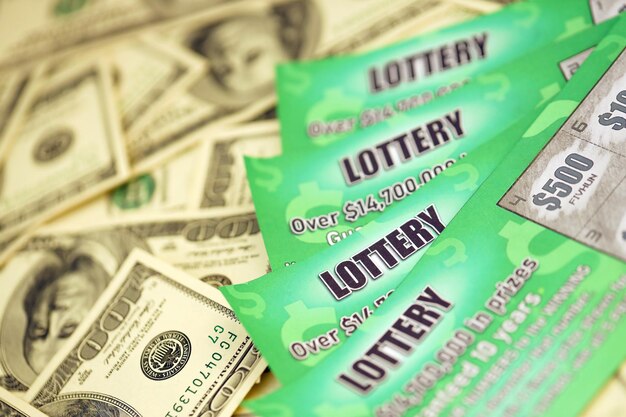Vue rapprochée des cartes à gratter de loterie verte et des billets en dollars américains Beaucoup ont utilisé de faux billets de loterie instantanée avec des résultats de jeu