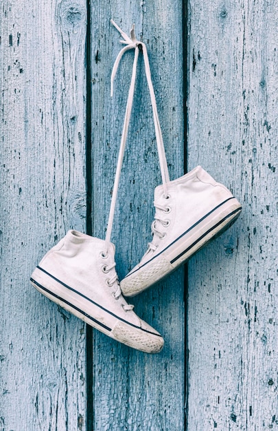 Photo vue rapprochée de chaussures accrochées à un mur de bois usé