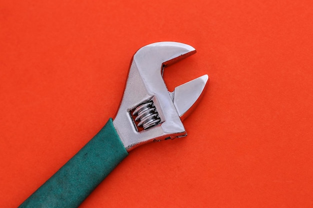 Vue rapprochée d'une clé anglaise réglable sur un fond orange