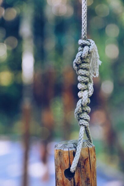 Photo vue rapprochée d'une corde attachée à un poteau de bois