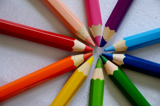 Vue rapprochée des crayons colorés disposés sur du papier blanc