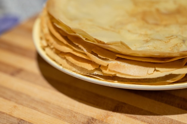 Vue rapprochée d'une délicieuse crêpe jaune aux bords croustillants sur une assiette blanche