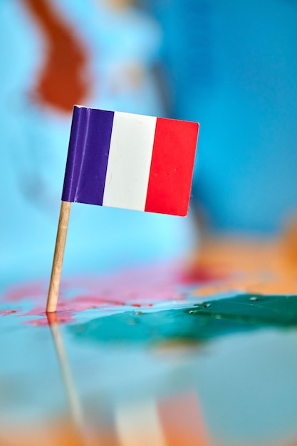 Vue rapprochée d'un drapeau de France avec un petit bâton sur la carte