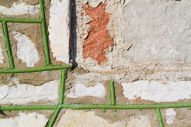 Vue rapprochée du béton usé et des tiges de fer rouillées à la lumière du jour