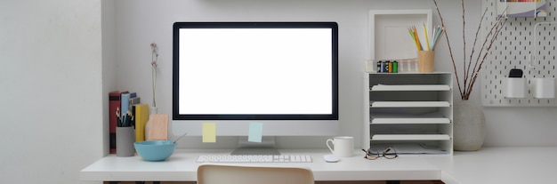 Vue rapprochée du bureau minimal avec ordinateur à écran blanc sur tableau blanc