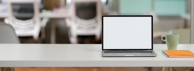 Vue rapprochée du bureau simple avec ordinateur portable à écran blanc et espace de copie