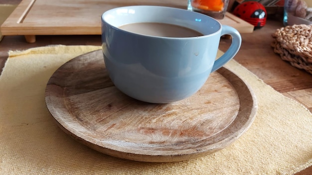 Vue rapprochée du café sur la table, des assiettes et des plats hipsters, une assiette en bois sous une tasse de café, une boisson chaude.