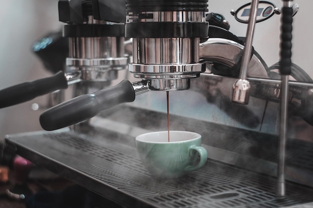 Vue rapprochée du café versé dans la tasse de la machine à expresso