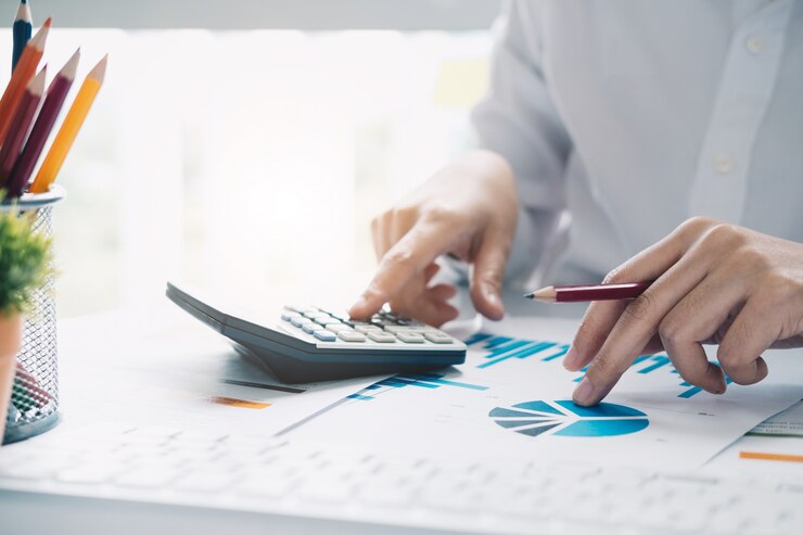 Photo vue rapprochée du comptable ou des mains de l'inspecteur financier faisant rapport, calculant ou vérifiant l'équilibre.
