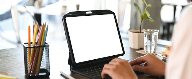 Vue rapprochée du concepteur de jeune femme tapant sur le clavier de la tablette numérique