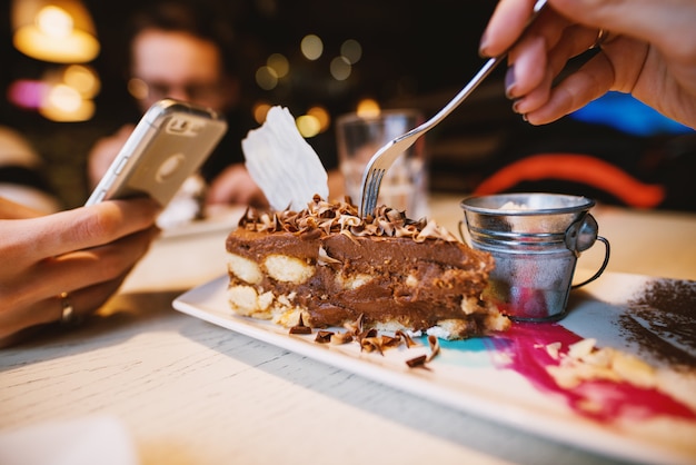 Vue rapprochée du gâteau au chocolat du désert avec de jolis petits pots de lait sur la plaque dans un restaurant.