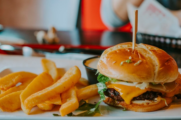 Photo vue rapprochée du hamburger et des frites sur la table