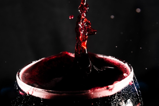 Vue rapprochée du haut d'une coupe en verre transparent remplie de vin avec des éclaboussures d'eau Effet d'éclaboussure