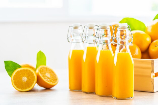 Photo vue rapprochée du jus d'orange dans des bouteilles de verre sur la table