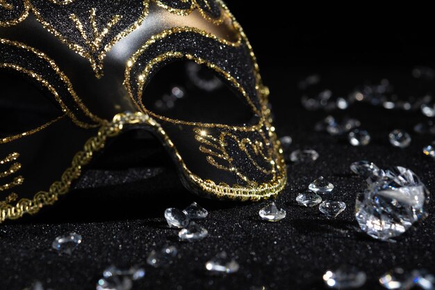 Photo vue rapprochée du masque d'or du carnaval avec des diamants sur fond noir