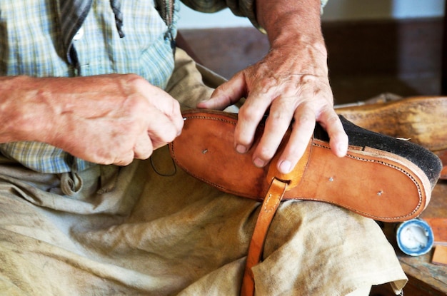 Photo vue rapprochée du milieu d'un homme cousant une chaussure