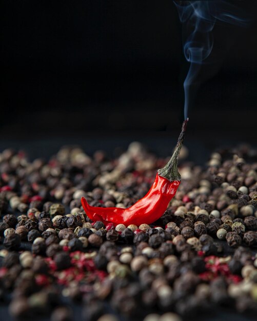 Photo vue rapprochée du piment rouge avec des grains de poivre autour