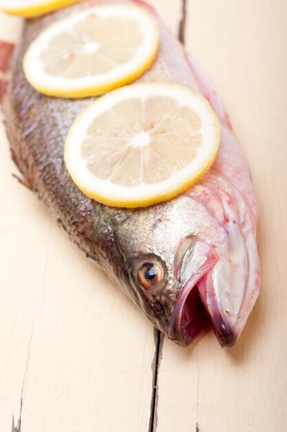 Photo vue rapprochée du poisson et du citron sur une table en bois