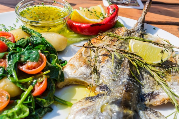 Vue rapprochée du poisson avec la salade servie dans l'assiette sur la table